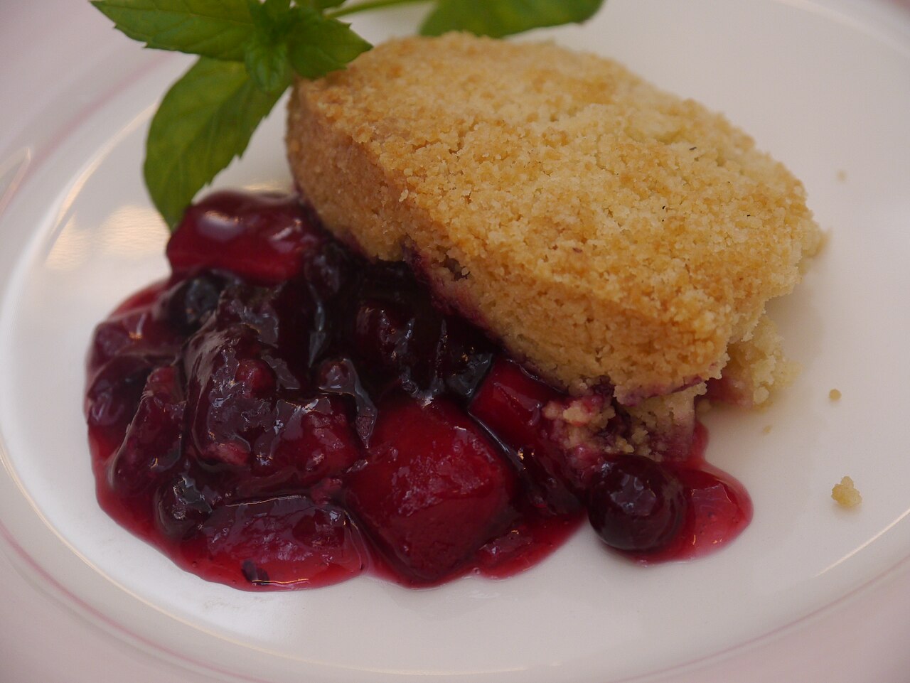 Black Currant - Apple and Blackcurrant crumble on a white plate