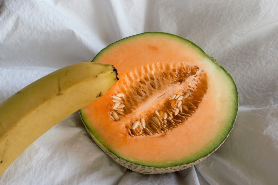 Cantaloupe - a half of a watermelon and a banana on a white cloth