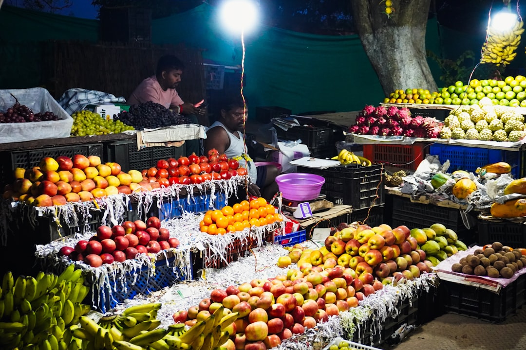 Cherimoya - A vibrant fruit stand at night with many colorful fruits.