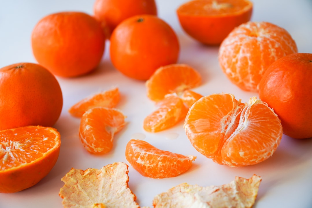 Clementine - sliced orange fruits on white ceramic plate
