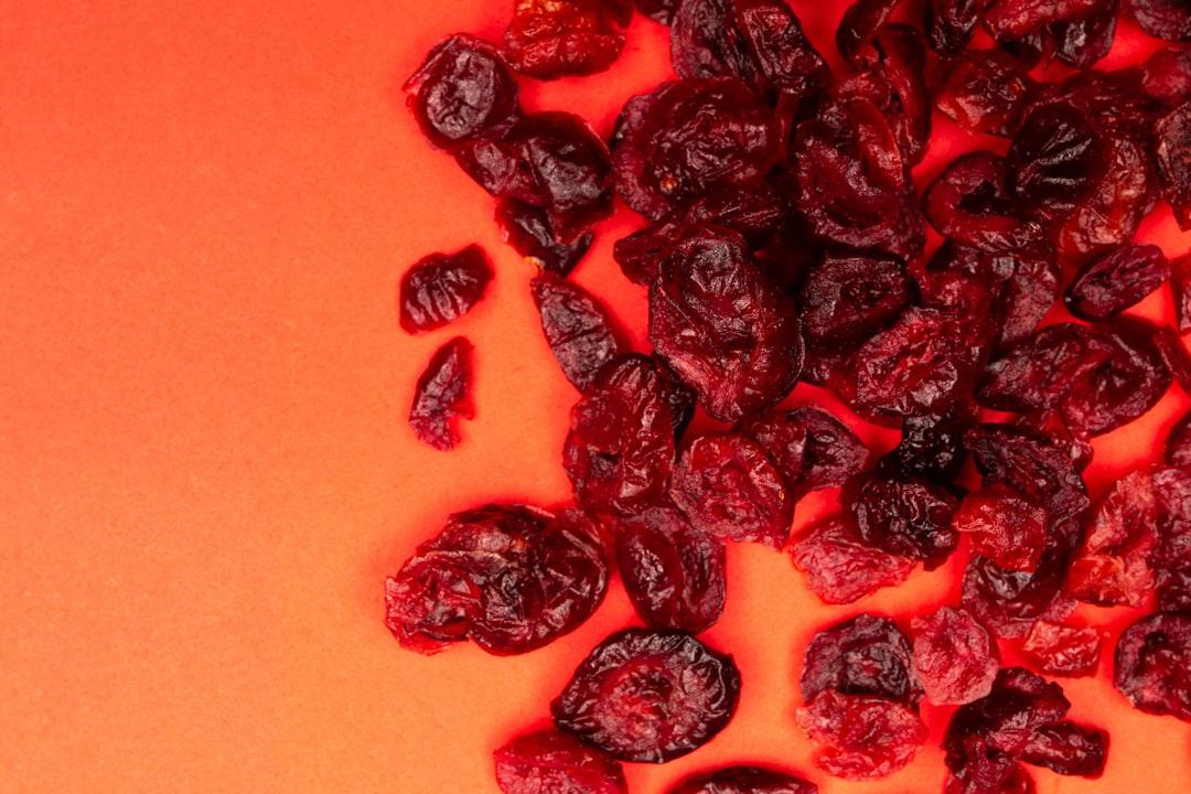 Cranberry - Dried cranberries scattered on a vibrant orange background