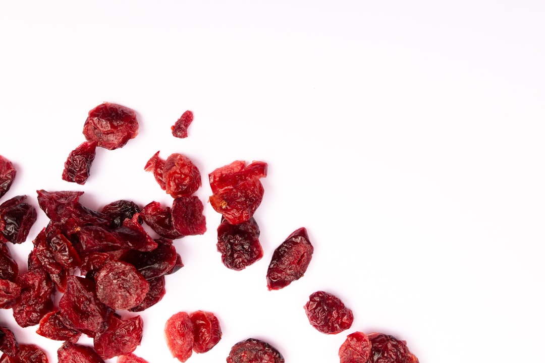 Cranberry - Dried cranberries scattered on a white surface