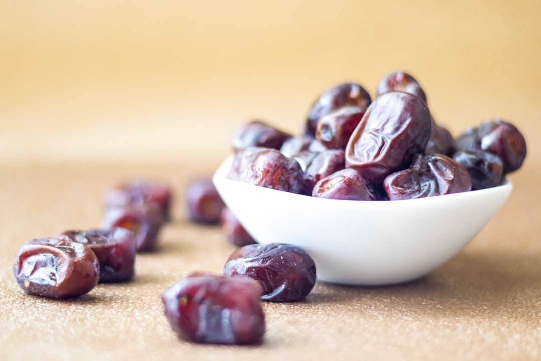 Date - brown round fruit on white ceramic bowl