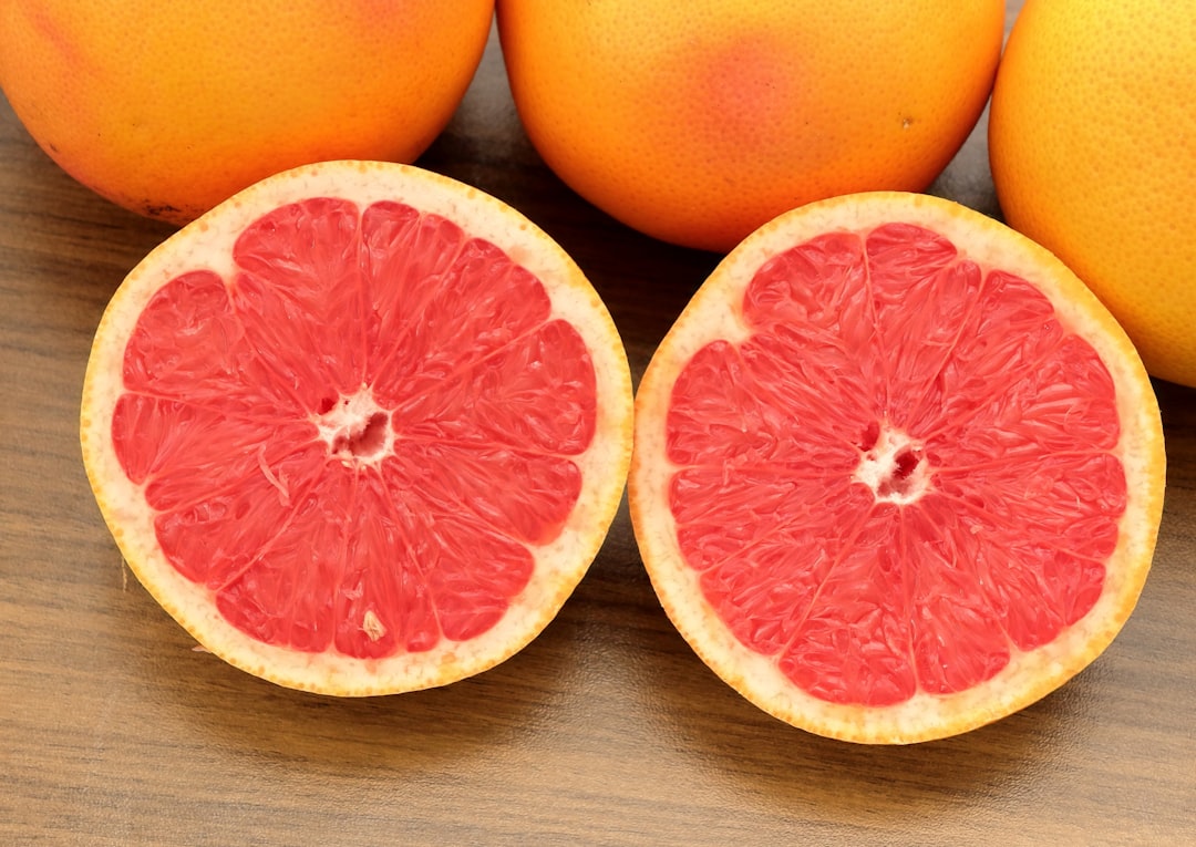 Grape - A group of grapefruits sitting on top of a wooden table
