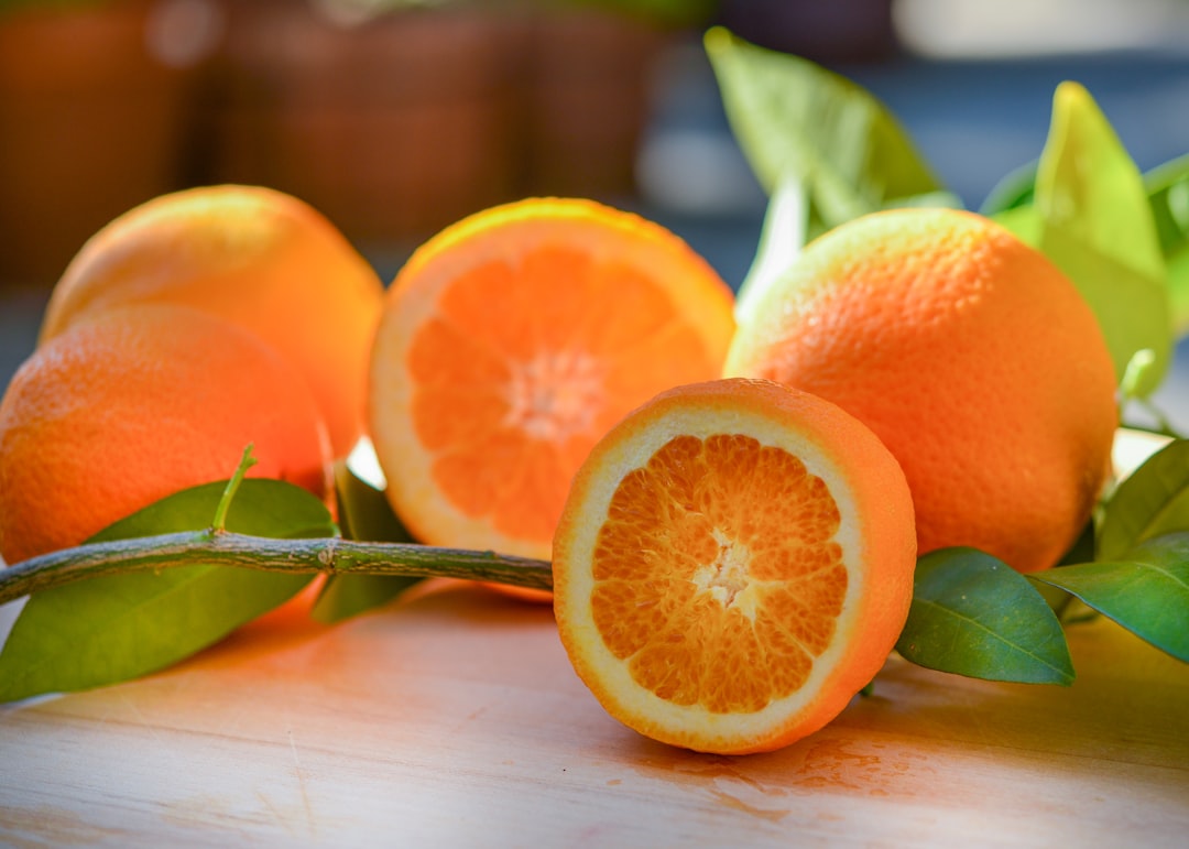 Orange - a group of oranges sitting on top of a wooden table