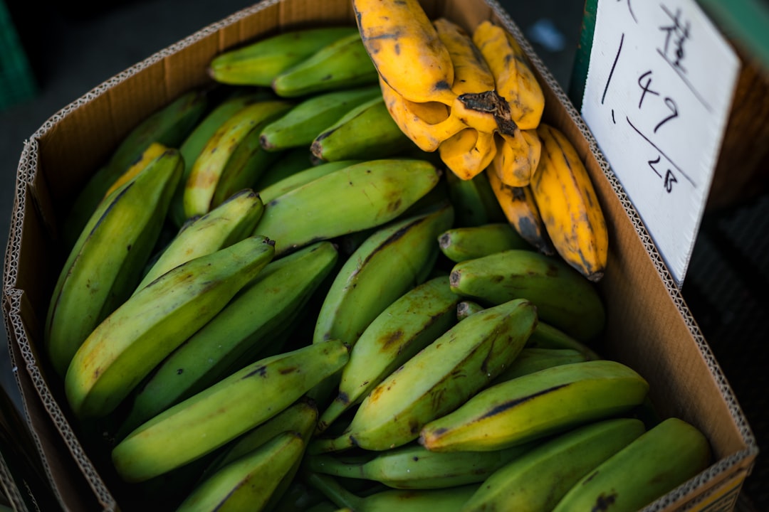 Plantain - A box of green and yellow bananas