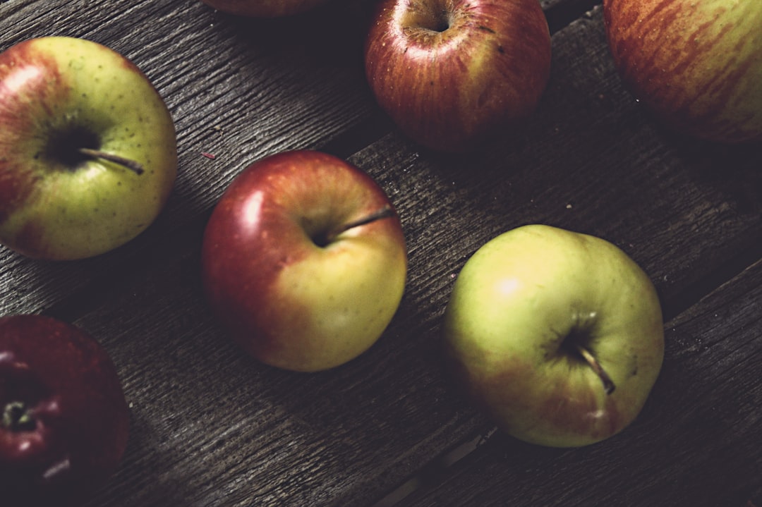 Wood Apple - a group of apples sitting on top of a wooden table